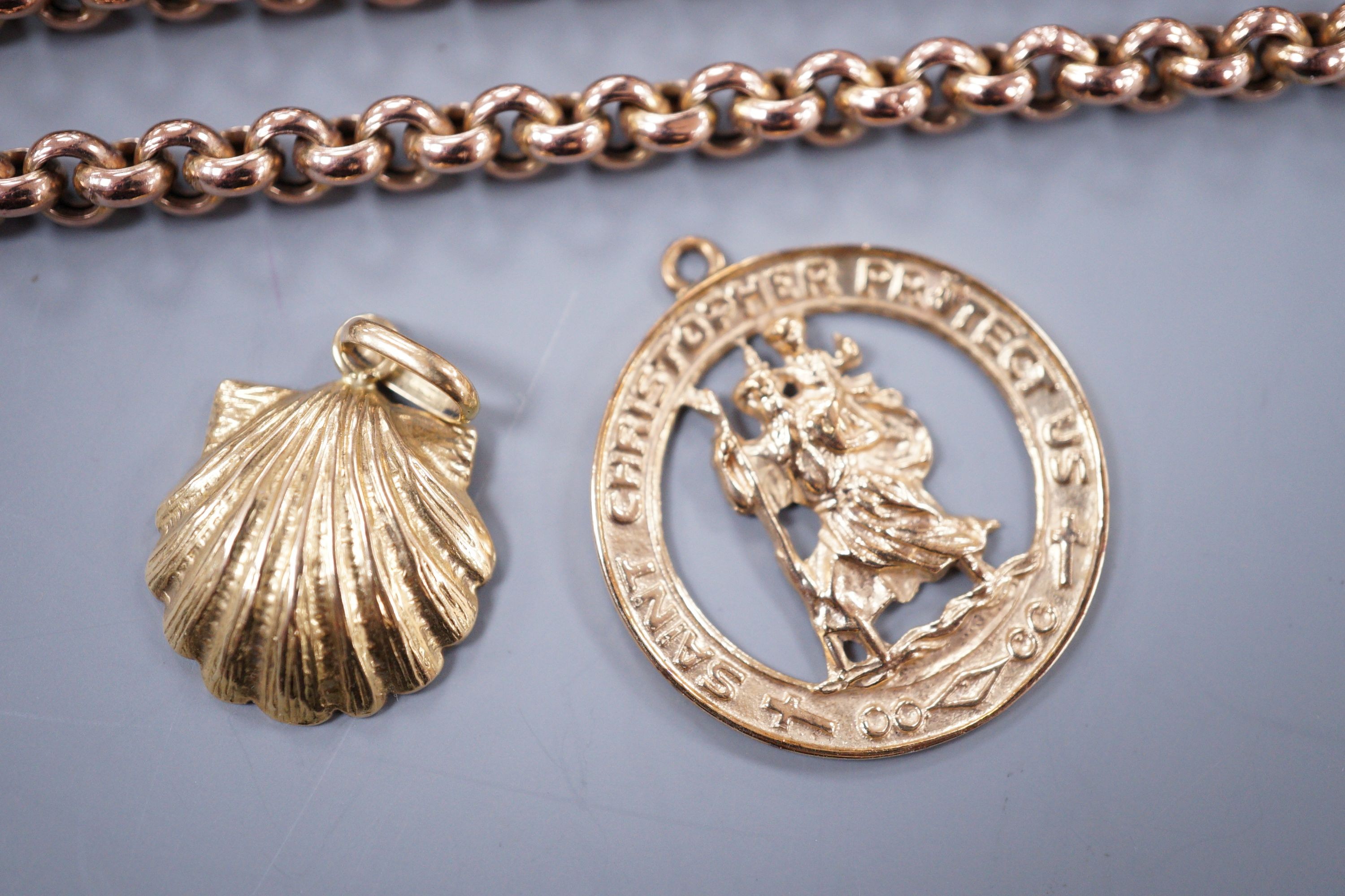 A modern 9ct gold St. Christopher pendant and a 750 yellow metal shell pendant, hung on a yellow metal belcher link chain, 58cm, gross weight 27.1 grams.